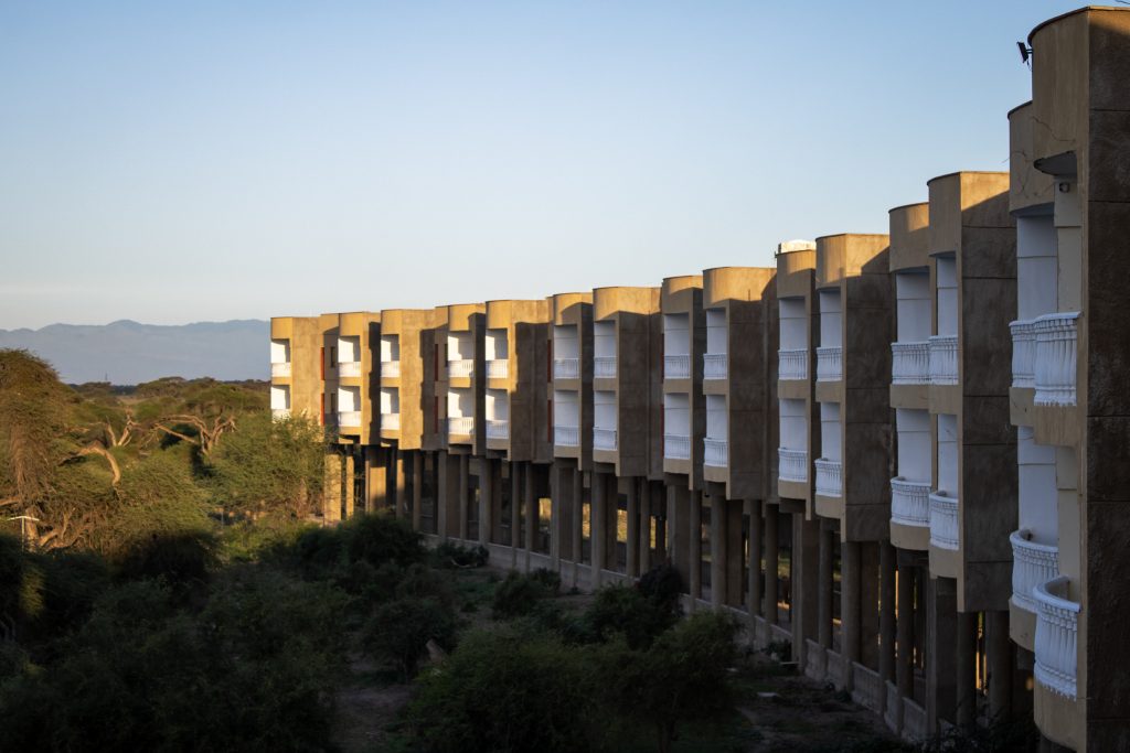 A multi-story hotel resort building overlooking a lush green landscape.