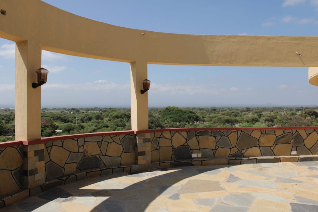 Panoramic view from the Anga Sky Bar terrace overlooking Kimana Sanctuary and the Chyulu Hills, with Mount Kilimanjaro on the horizon.