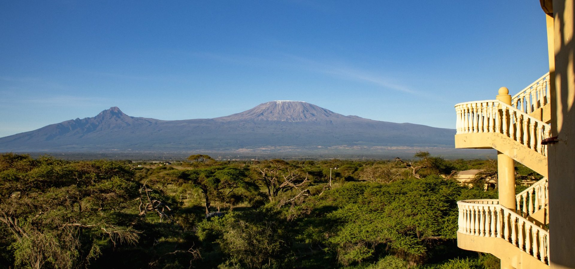 Panorama of Mount Kilimanjaro and green bushland viewed from Executive Terrace Rooms at Amboseli Safari Club.