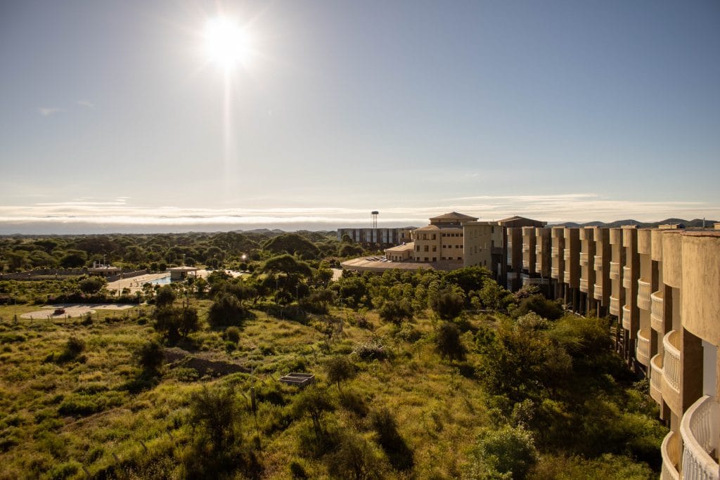 Elevated view of Amboseli Safari Club overlooking lush savannah under bright sun.